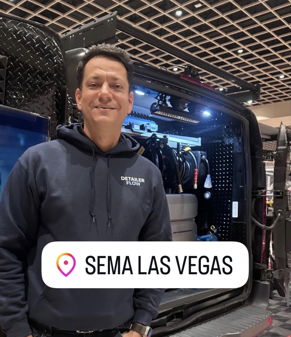 Detailer Flow representative at SEMA Las Vegas beside a mobile detailing van